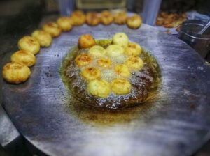 A photo of Aloo Tikki patties being fried on a tawa, a flat Indian griddle, until they are crispy and golden brown. A key step in the preparation of this popular Indian street food snack