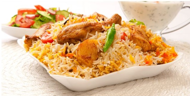 A steaming hot and appetizing plate of traditional chicken biryani, overflowing with aromatic spices and juicy pieces of chicken