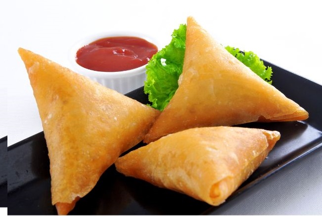 Golden brown, flaky pastry filled with spicy vegetables or meat, served hot as a snack or appetizer